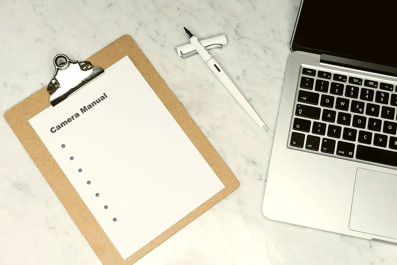 A laptop and notebook showing company research notes for a targeted job search.