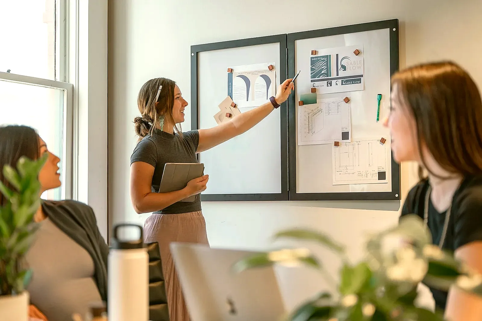 A professional leading a team meeting in an office setting.