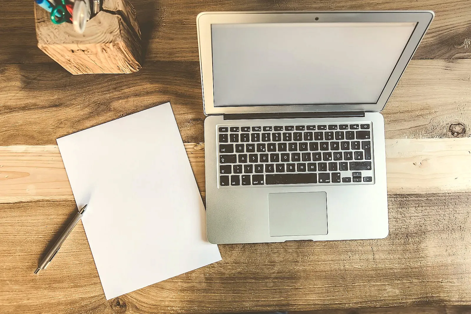 A tailored cover letter draft on a laptop screen with company-specific details.